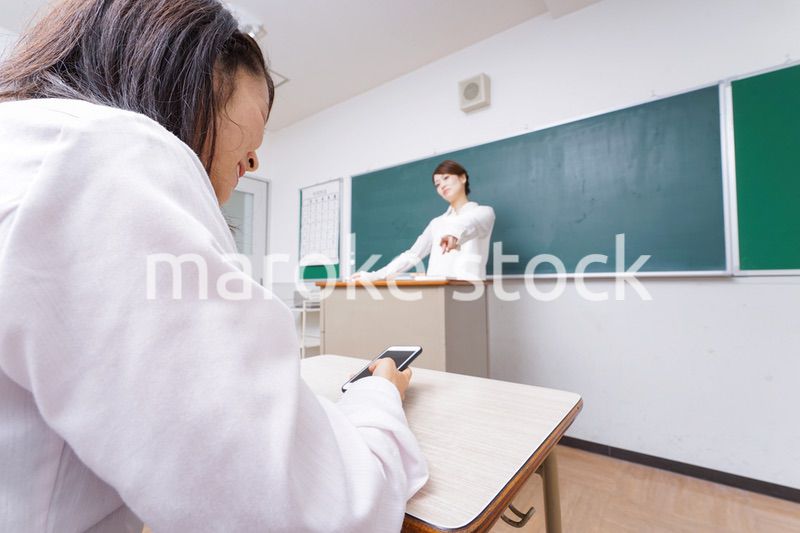 授業中にスマホを使う学生と注意する教師