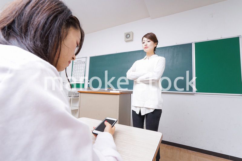 授業中にスマホを使う学生と注意する教師
