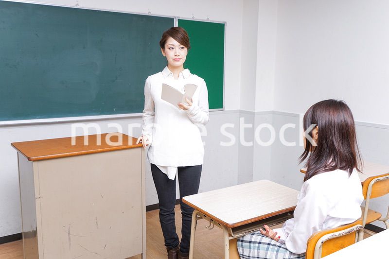 本を持って授業をする女性教師