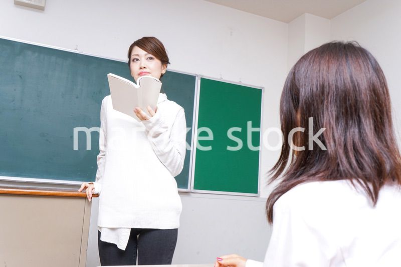 本を持って授業をする女性教師