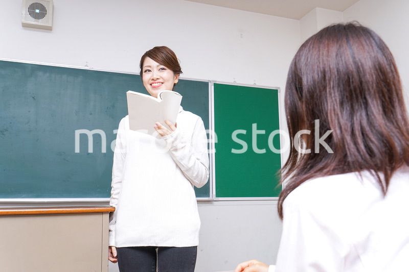 本を持って授業をする女性教師