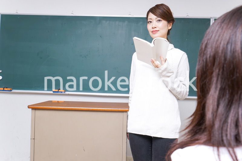 本を持って授業をする女性教師