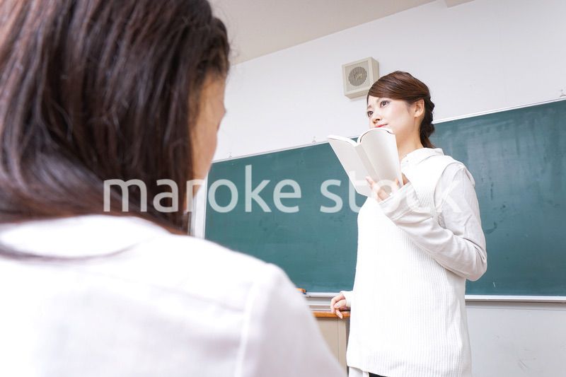 本を持って授業をする女性教師