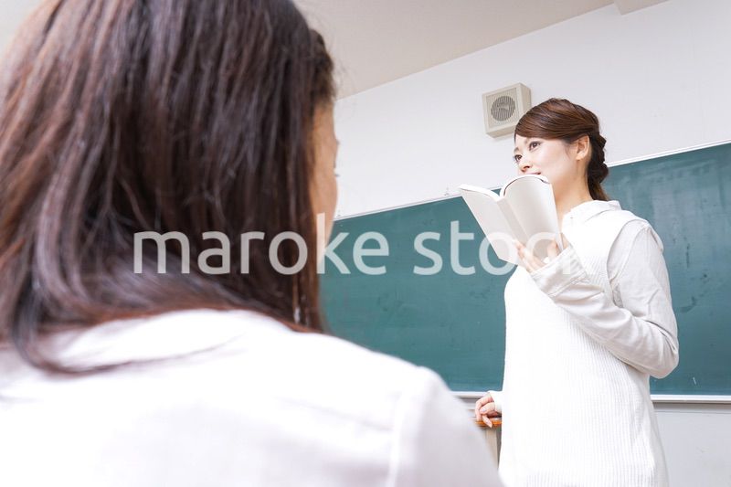 本を持って授業をする女性教師