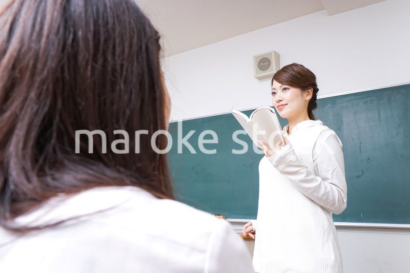 本を持って授業をする女性教師