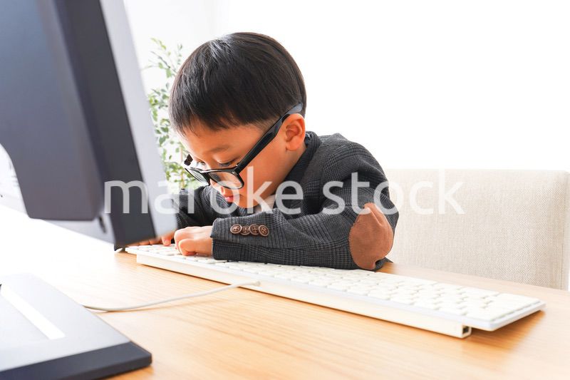 スーツを着て仕事をする子供ビジネスマン