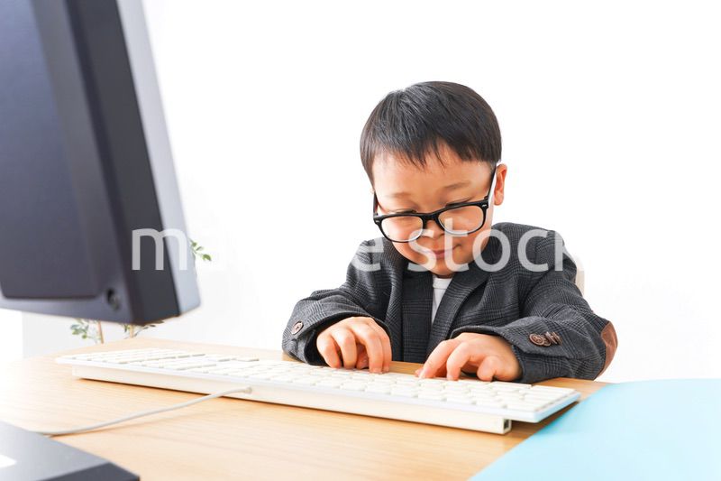 スーツを着て仕事をする子供ビジネスマン