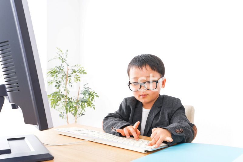 スーツを着て仕事をする子供ビジネスマン
