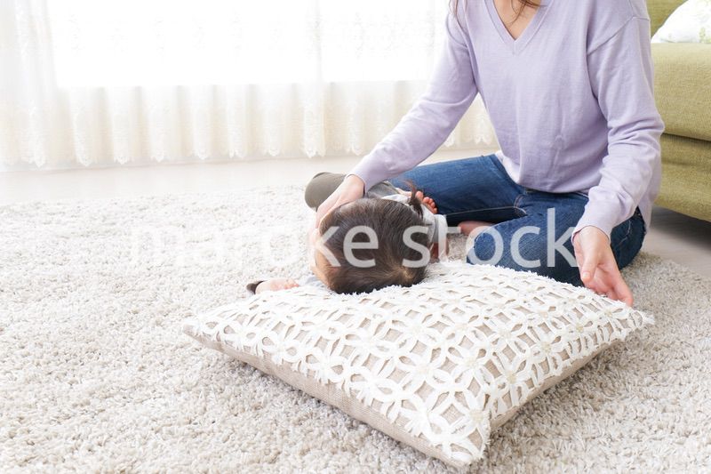 子どもを寝かせるお母さん