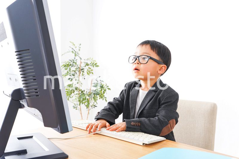 スーツを着て仕事をする子供ビジネスマン