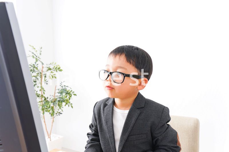 スーツを着て仕事をする子供ビジネスマン