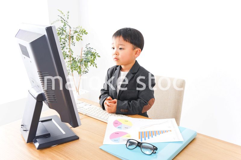 スーツを着て仕事をする子供ビジネスマン