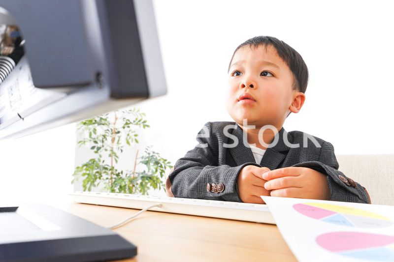 スーツを着て仕事をする子供ビジネスマン