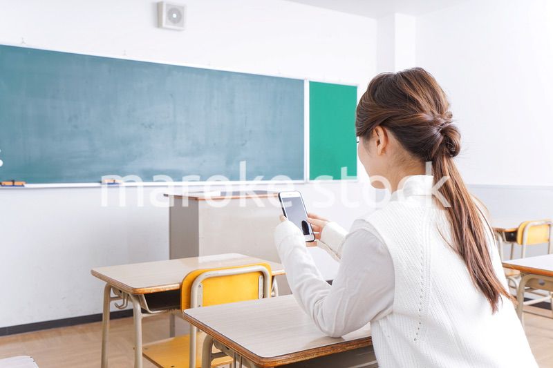 教室で携帯電話を使う学生
