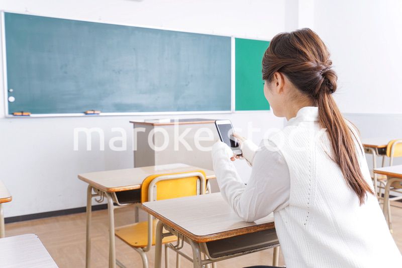 教室で携帯電話を使う学生