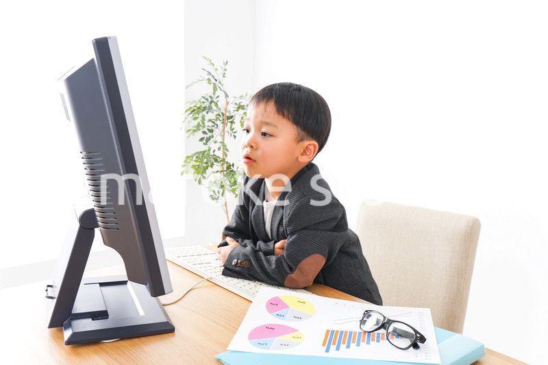 スーツを着て仕事をする子供ビジネスマン