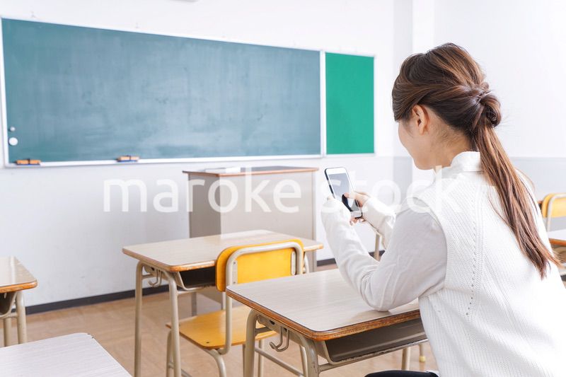 教室で携帯電話を使う学生