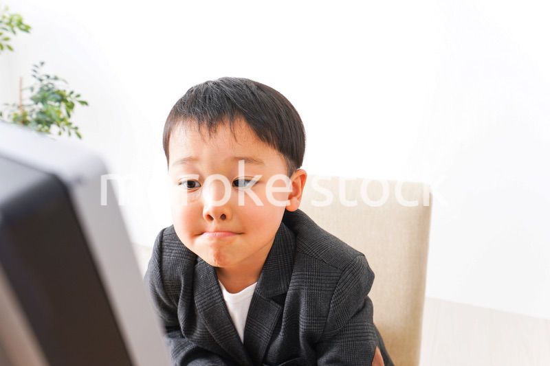 スーツを着て仕事をする子供ビジネスマン