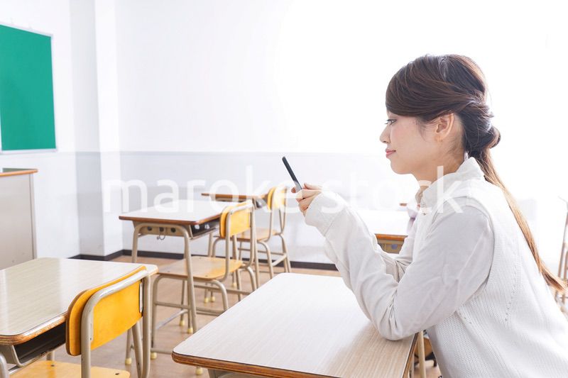 教室で携帯電話を使う学生