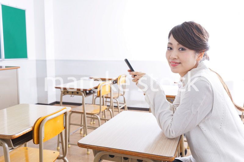 教室で携帯電話を使う学生