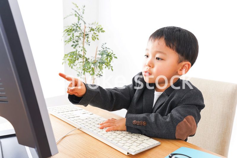スーツを着て仕事をする子供ビジネスマン