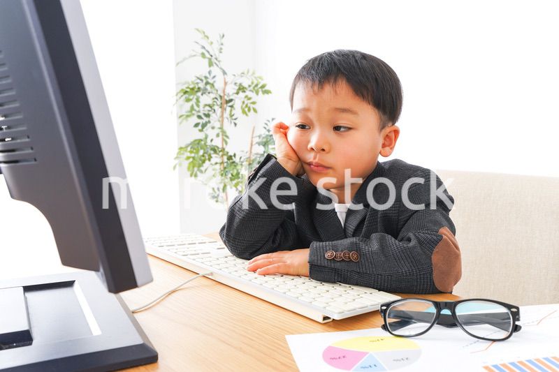 スーツを着て仕事をする子供ビジネスマン