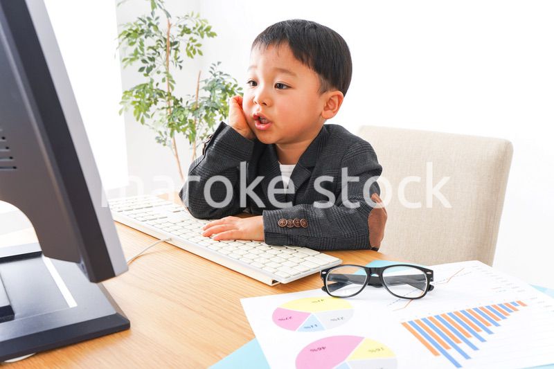 スーツを着て仕事をする子供ビジネスマン