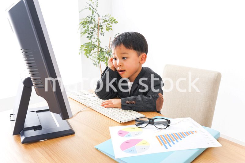 スーツを着て仕事をする子供ビジネスマン