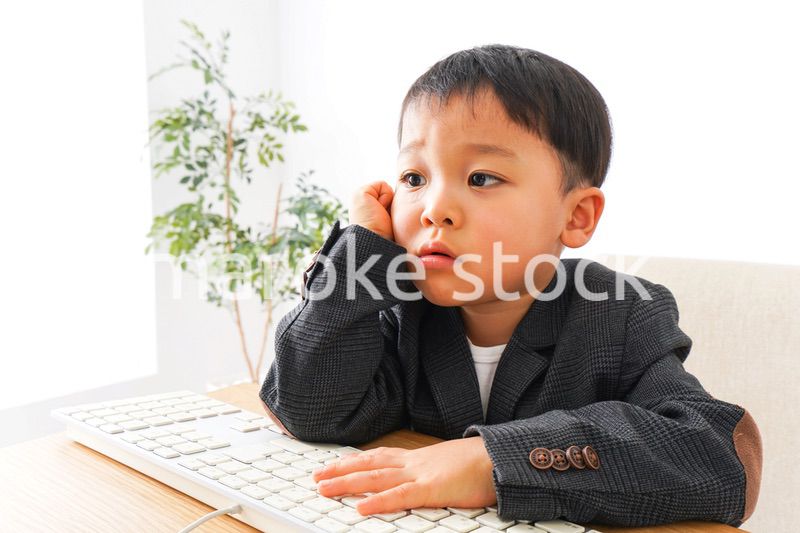 スーツを着て仕事をする子供ビジネスマン