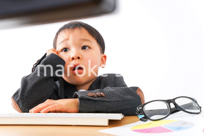 スーツを着て仕事をする子供ビジネスマン