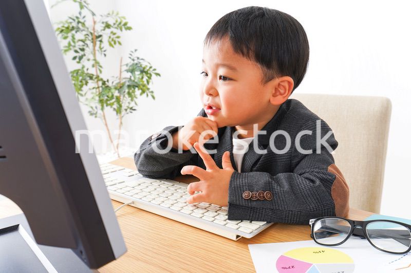 スーツを着て仕事をする子供ビジネスマン