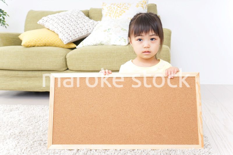 泣きながらボードを持つ子供