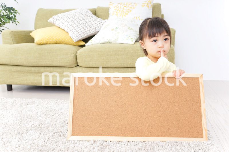 泣きながらボードを持つ子供