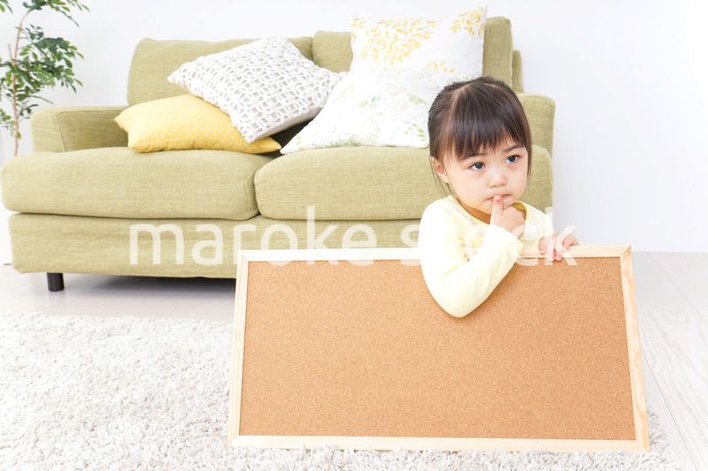 泣きながらボードを持つ子供