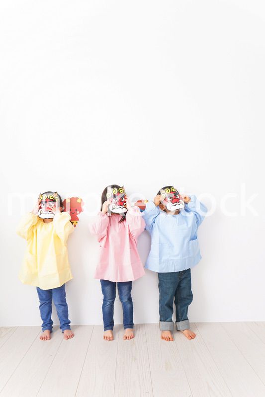 節分のお面をかぶる子どもたち
