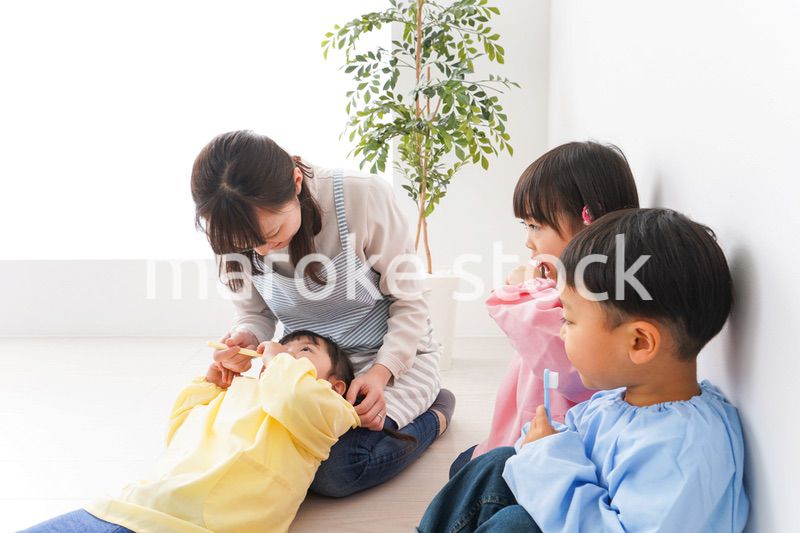 子どもたちに歯磨きの指導をする先生