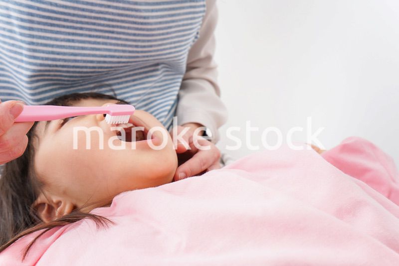 子供の歯を磨くお母さん