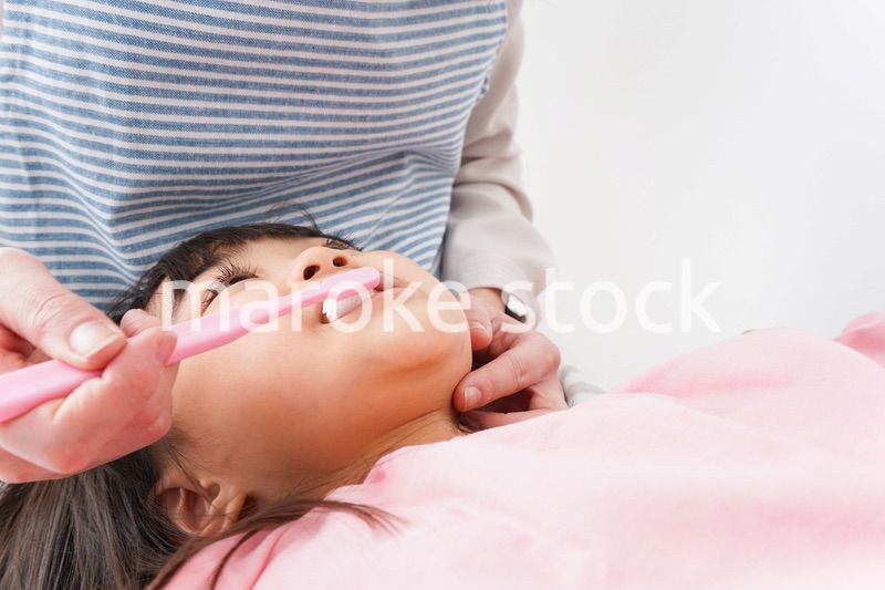 子供の歯を磨くお母さん