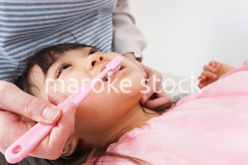 子供の歯を磨くお母さん