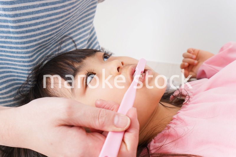 子供の歯を磨くお母さん