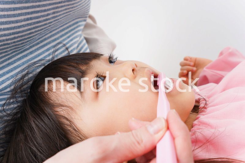 子供の歯を磨くお母さん