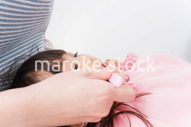 子供の歯を磨くお母さん