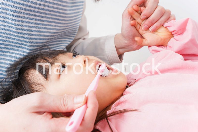 子供の歯を磨くお母さん