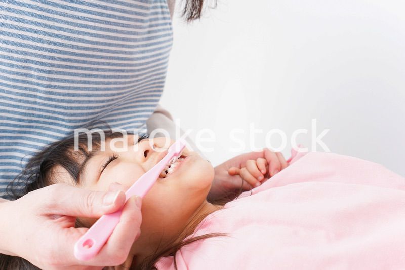 子供の歯を磨くお母さん