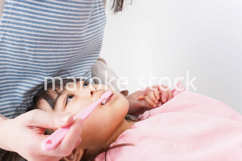 子供の歯を磨くお母さん