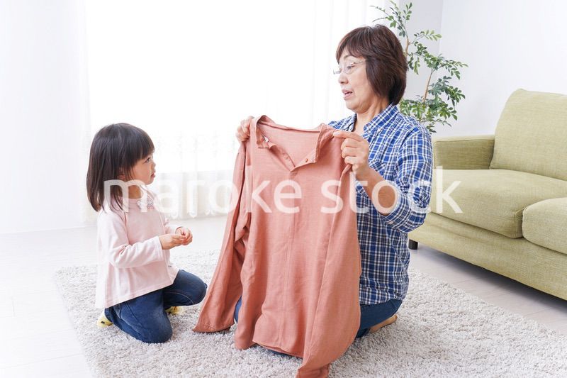 洗濯物をたたむおばあさんと子ども