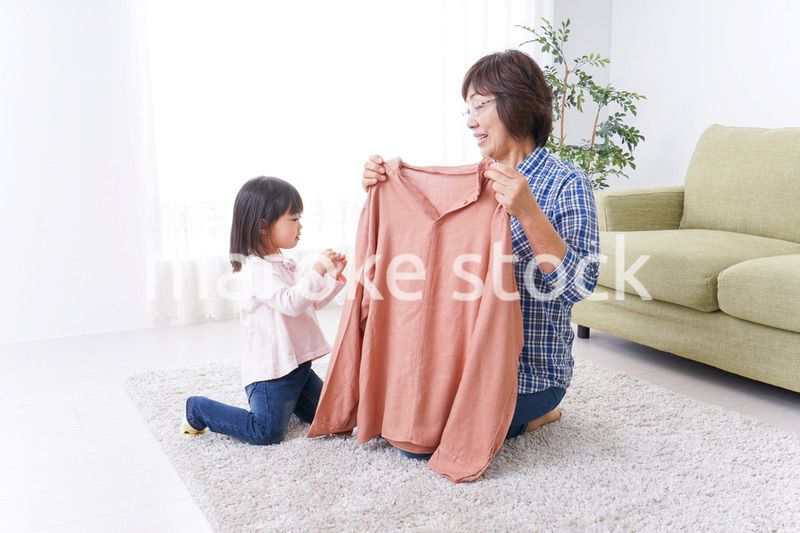 洗濯物をたたむおばあさんと子ども