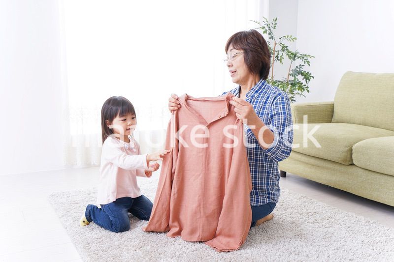 洗濯物をたたむおばあさんと子ども