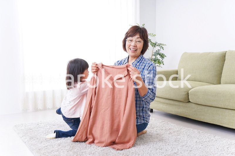 洗濯物をたたむおばあさんと子ども