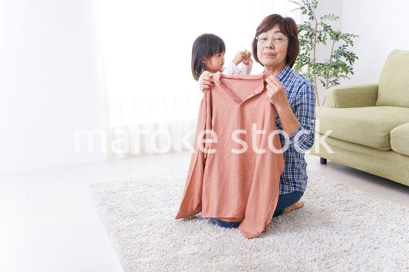 洗濯物をたたむおばあさんと子ども